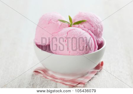 Scoops pink ice cream in bowl on rustic wooden vintage table background.