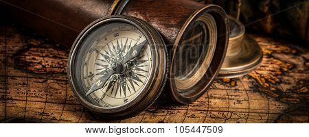Travel geography navigation concept background - letterbox panorama of old vintage retro compass with sundial, spyglass and rope on ancient world map