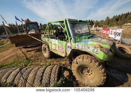 RUSSIA, PUSHKINO -?? 20 SEP, 2014: Bulldozer pulls offroad from a dirty pond on Rainforest Challenge Russia Autumn 2014 PRO-X.