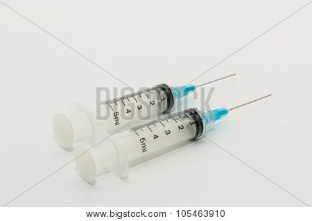 Two disposable 5ml syringes with blue needles