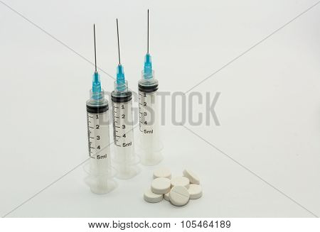 Five ml disposable plastic syringes blue needles white pills