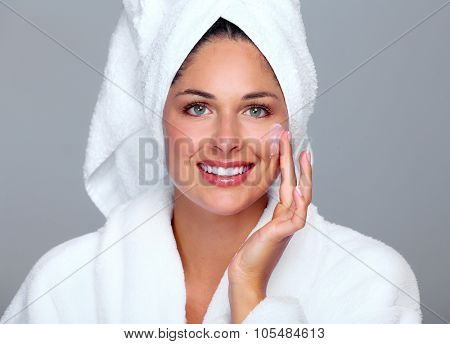 Beautiful woman face with moisturising cream. Skin care background.