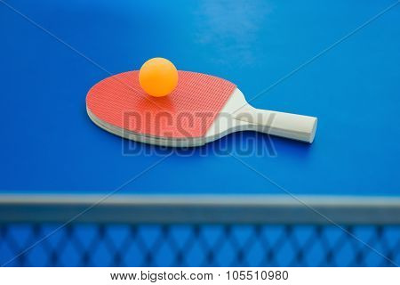 Pingpong Racket And Ball And Net On A Blue Pingpong Table