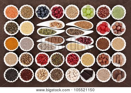 Health and diet superfood food selection in porcelain bowls over lokta paper background. High in vitamins and antioxidants.