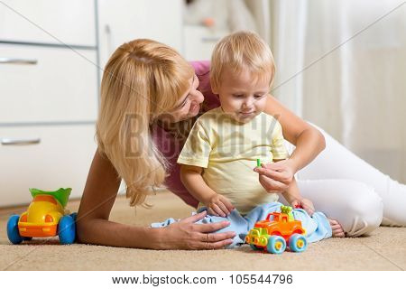 kid boy and his mother repair toy car at home