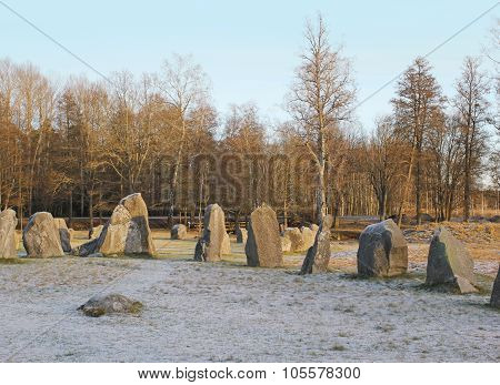 The big stones standing in the snow field in winter