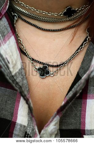 The woman decolette in plaid shirt with black and silver necklace