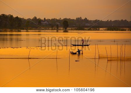 Fisher on boat in water season in sunrise in Dong Thap, Vietnam