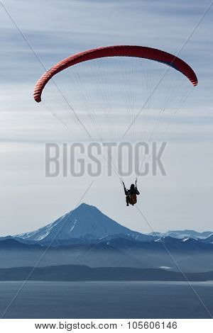 Paraglider Flying On Background Of Volcano And Sea