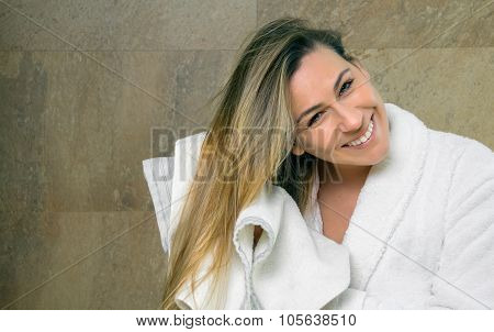 Young woman wiping wet hair with a towel
