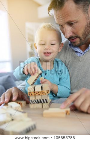 Daddy with 2-year-old boy playing with wooden blocks