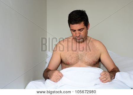 Upset Man In His Forties (40S) In Bed Looking Down At His Penis