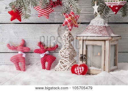 Christmas still life decoration with lantern, cariboo, tree and sledge on wooden background