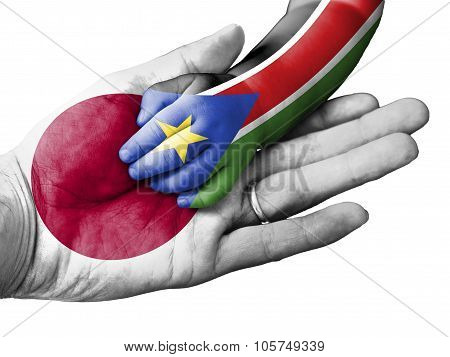 Adult Man Holding A Baby Hand With Japan And South Sudan Flags Overlaid. Isolated On White