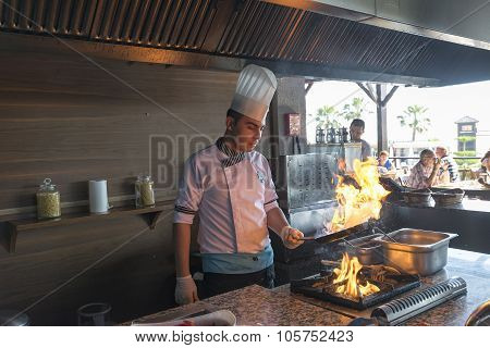 ISTANBUL TURKEY SEPT 28 2014 Chef in restaurant kitchen doing flambe on food