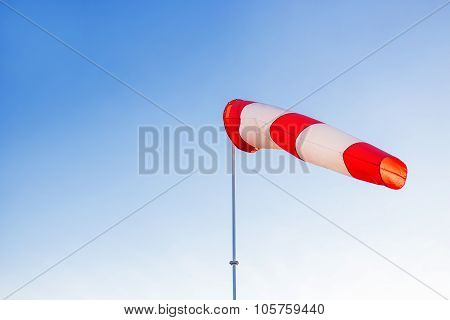 A Red Wind Vane Against A Clear Blue Sky.