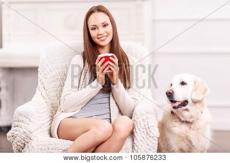 Pretty girl in the armchair with her pet around.