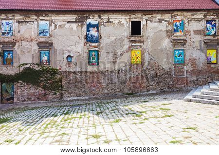 Neglected House With Mural Paintings In Windows