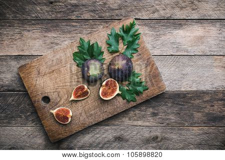 Cut Figs On Chopping Board And Wood Table