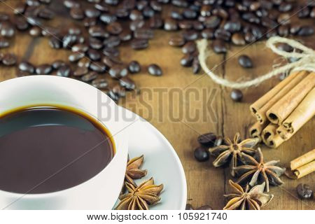 Coffee On The Cup With Coffee Beans And Cinnamon Sticks On Wood Background ,  Warm Toning, Selective