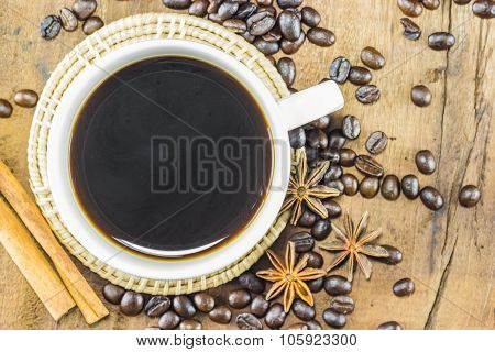 Coffee On The Cup With Coffee Beans And Cinnamon Sticks On Wood Background, Warm Toning, Selective F