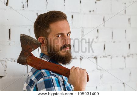 Young bearded lumberjack with red axe