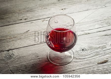 Glass white wine and bunch grapes on background of wooden