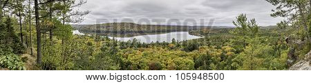 Panorama Looking Out Over A Lake Surrounded By Forest In Autumn