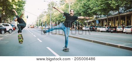 Two Happy And Funny Skaters Ride Skateboard On City Street