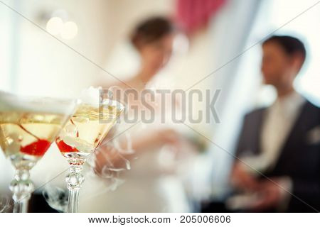 glasses of champigne against the background of the bride and groom. Wedding concept