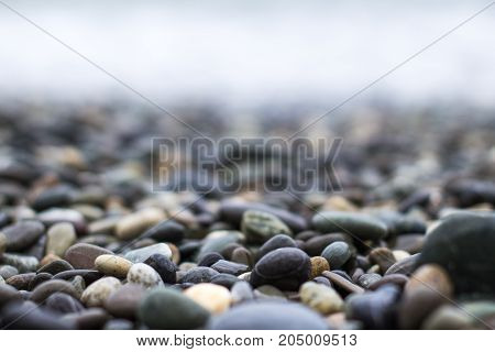Wet Sea Pebbles With A Wave After A Storm With A Shallow Depth Of Field