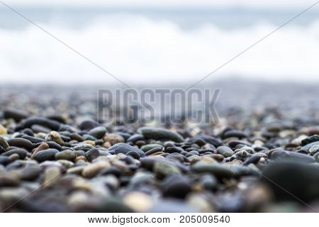 Wet Sea Pebbles With A Wave After A Storm With A Shallow Depth Of Field