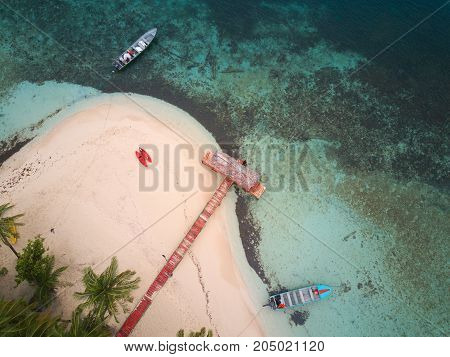 Colorful boats on private island aerial above view