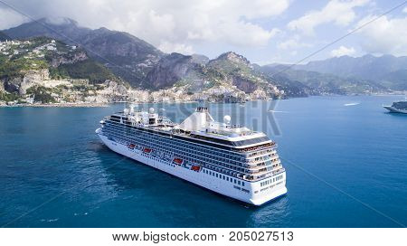 big cruise ship in sea near high mountain
