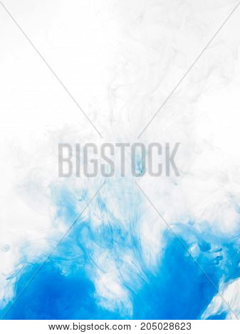 Ink swirl in water isolated on white background. The paint in the water. Soft dissemination a droplets of blue ink in water close-up. Abstract background. Soft focus.