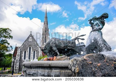 COPENHAGEN, DENMARK - JULY 20: Gefion Fountain and St. Alban's Church, a large fountain on harbor front and the most popular tourist destination in Copenhagen, Denmark