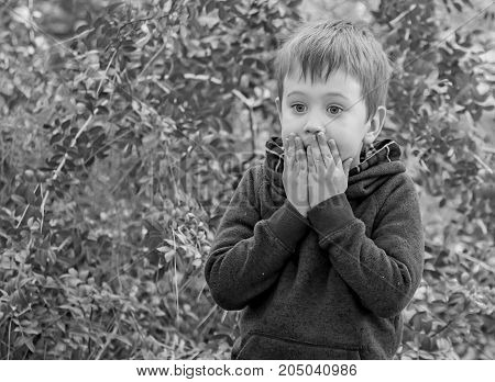 A scared closeup facial expression of a Caucasian child, black and white image. 