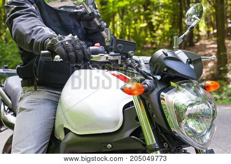 Picture of a motorcycle parked on a country road in a forest