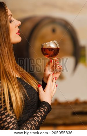 Woman Tasting Wine In Rural Cottage Interior