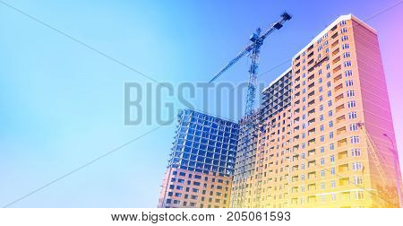 Multi-storey building under construction. Building. Unfinished house. Lifting crane. The concept of development. Toned photo.