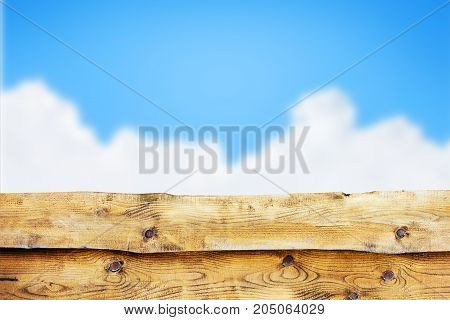 Wooden fence against blue sky with clouds background