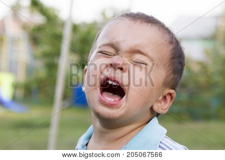 Angry, Sad And Unhappy Baby Child. Shouting And Crying. Problem Child With Head In Hands. Concept Fo
