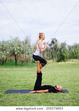 Photo of practicing yoga outdoor. Doing yoga fitness. Exercise for relax and healthy body.