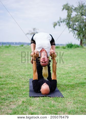 Photo of practicing yoga outdoor. Doing yoga fitness. Exercise for relax and healthy body.