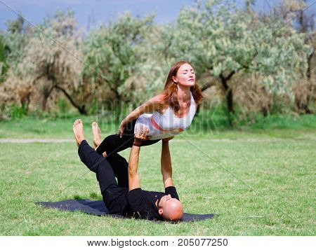 Photo of practicing yoga outdoor. Doing yoga fitness. Exercise for relax and healthy body.