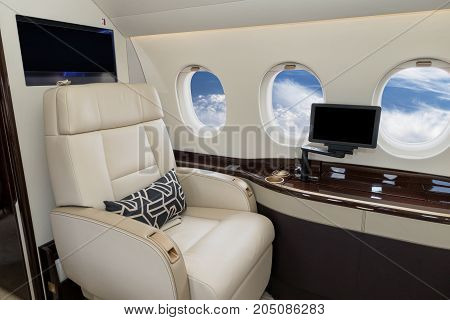Comfortible cabin chair in a modern business jet during flight.