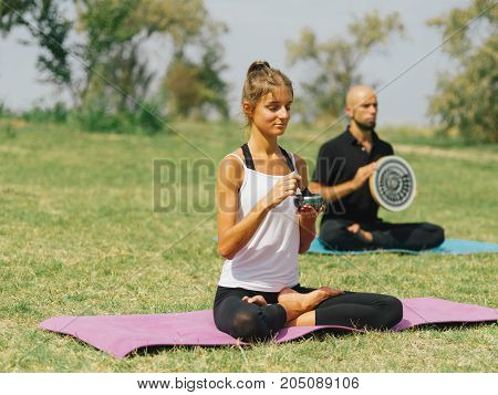 People at the health club outside with personal trainer, learning the correct form.