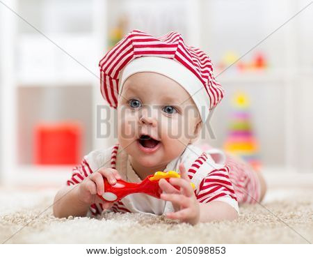 baby lying on the floor and plays with toy indoor