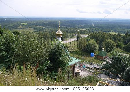 View from the mountain on the woody area with an orthodox chapel at the foot of a hill