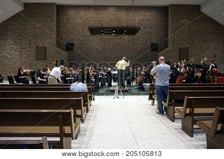 ROMEOVILLE, ILLINOIS / UNITED STATES - MAY 21, 2017: Dr. Lawrence Sisk conducts the Metropolitan Youth Symphony Orchestra (MYSO) in a dress rehearsal prior to a concert in Borromeo Hall at Lewis University.